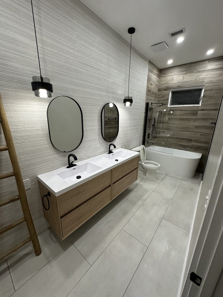 Floating double vanity, oval mirrors and contemporary tile finishes