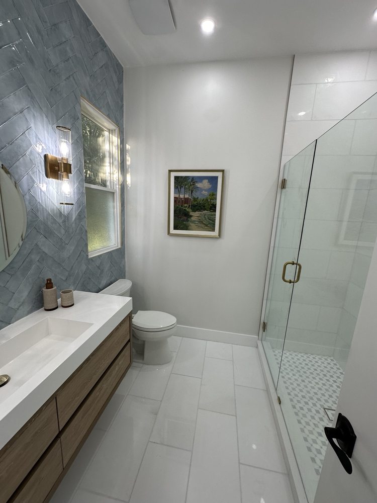 Bathroom with an illuminated mirror, vanity and glass shower panel