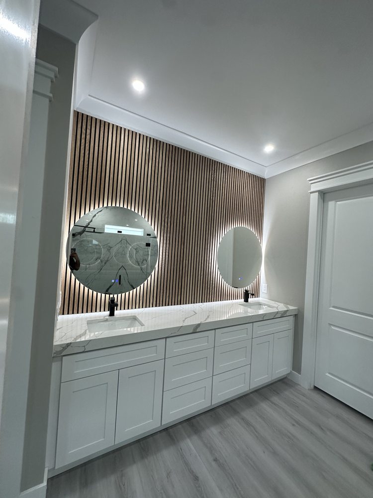 Double vanity, round mirrors and a slatted wood-look feature wall