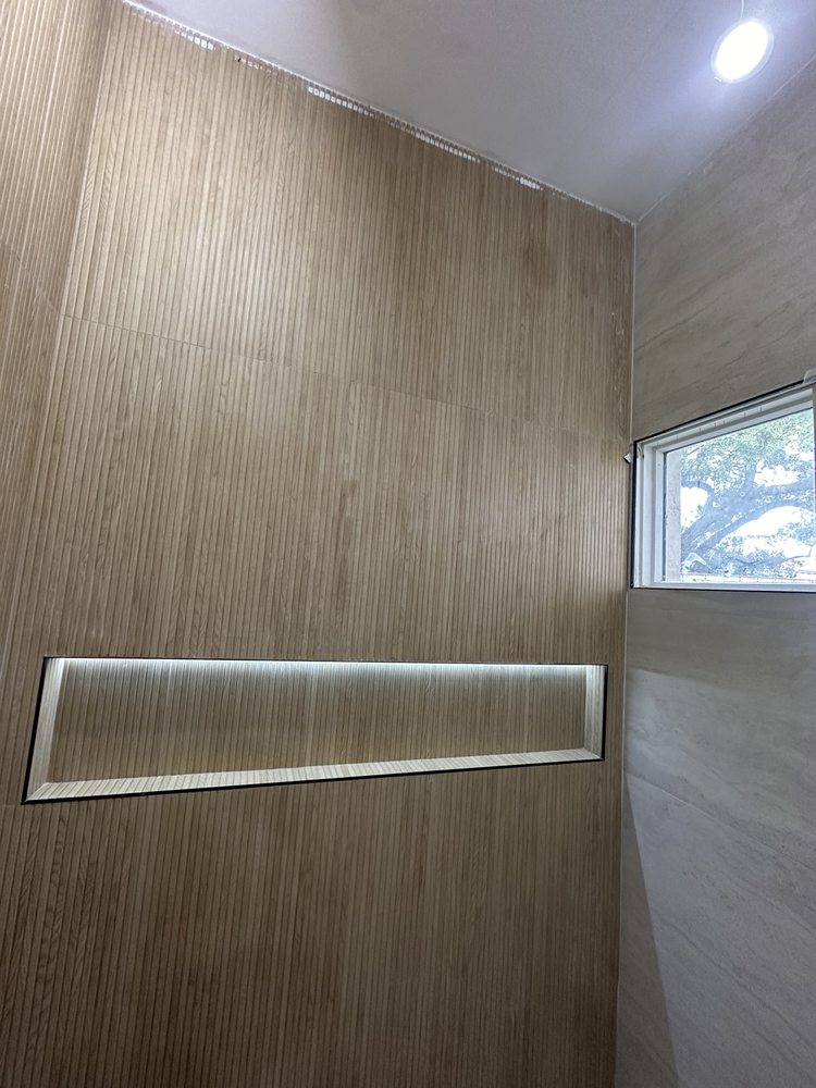 Wood-look tile wall with a long illuminated recessed niche
