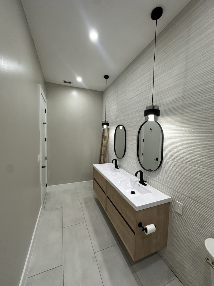 Floating double vanity and oval mirrors viewed from the bathroom entrance