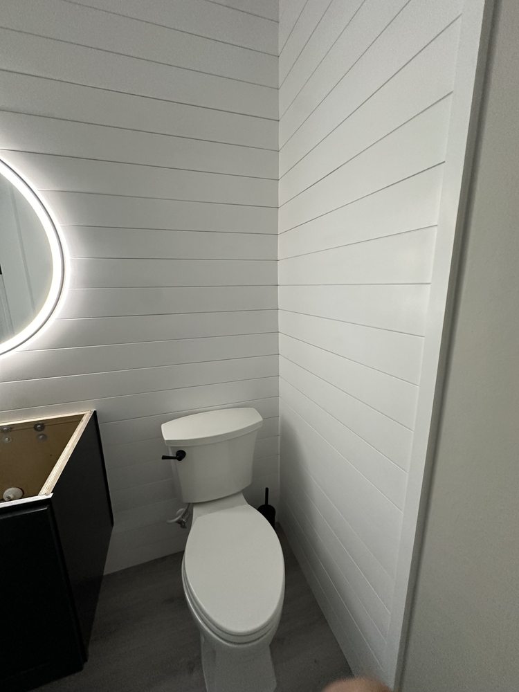 White horizontal bathroom wall paneling during vanity installation