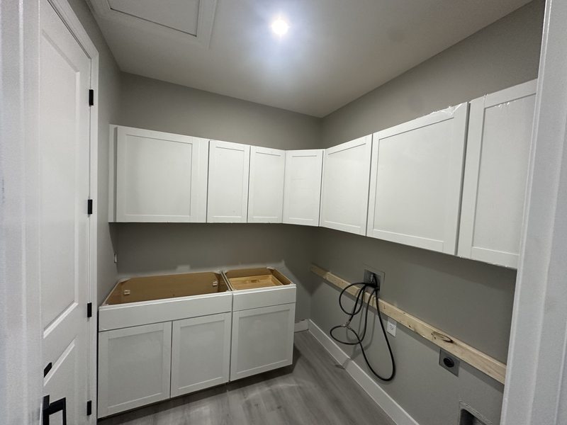 White upper and lower laundry cabinets during installation