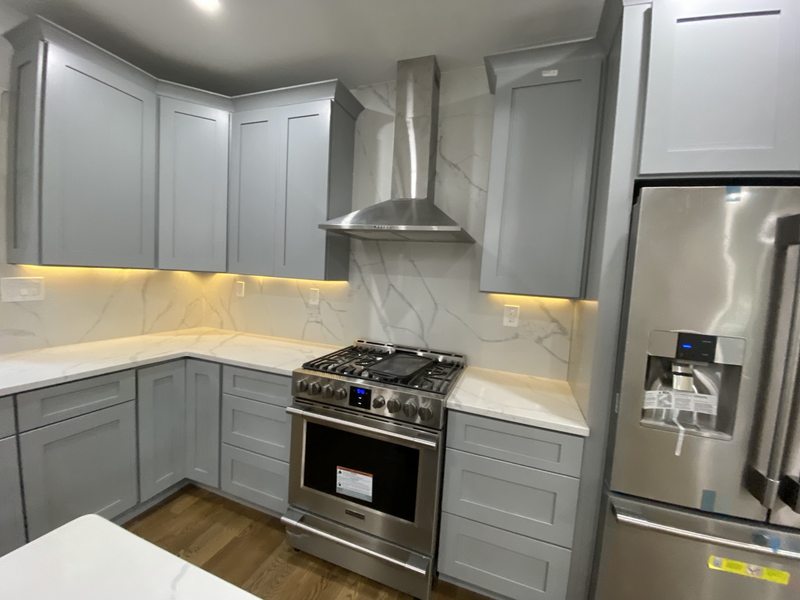 Gray kitchen cabinets, marble-look backsplash and under-cabinet lighting
