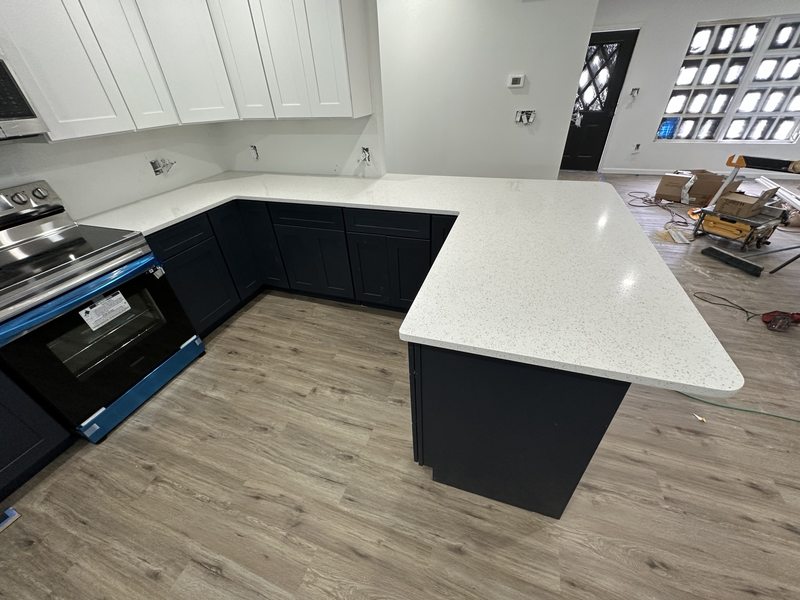 White peninsula countertop and dark base cabinets during kitchen installation