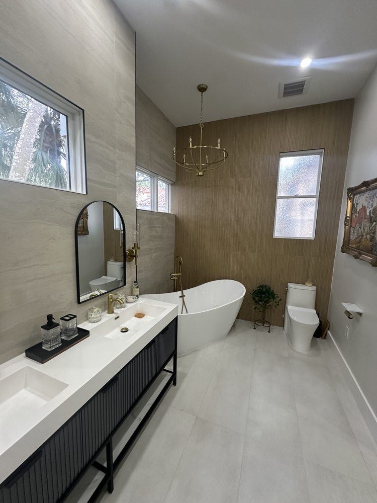 Bathroom vanity, freestanding bathtub and gold plumbing fixtures