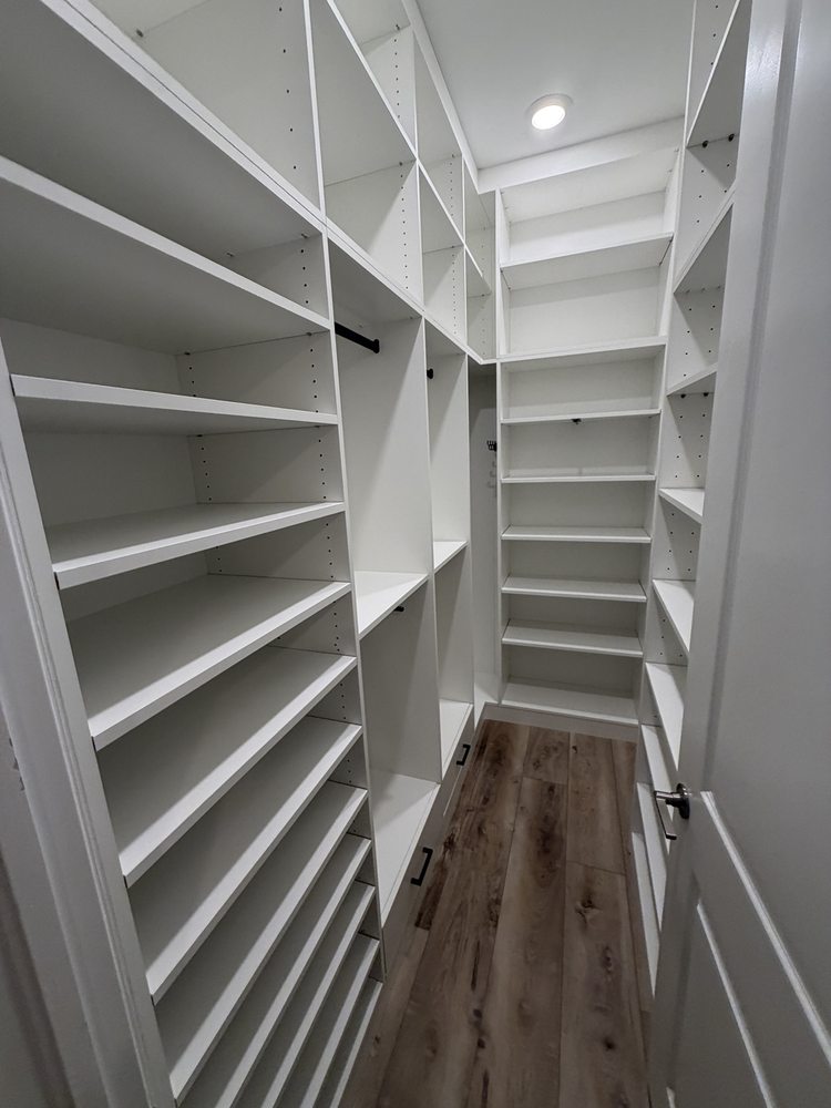 White walk-in closet shelving, hanging rails and drawers