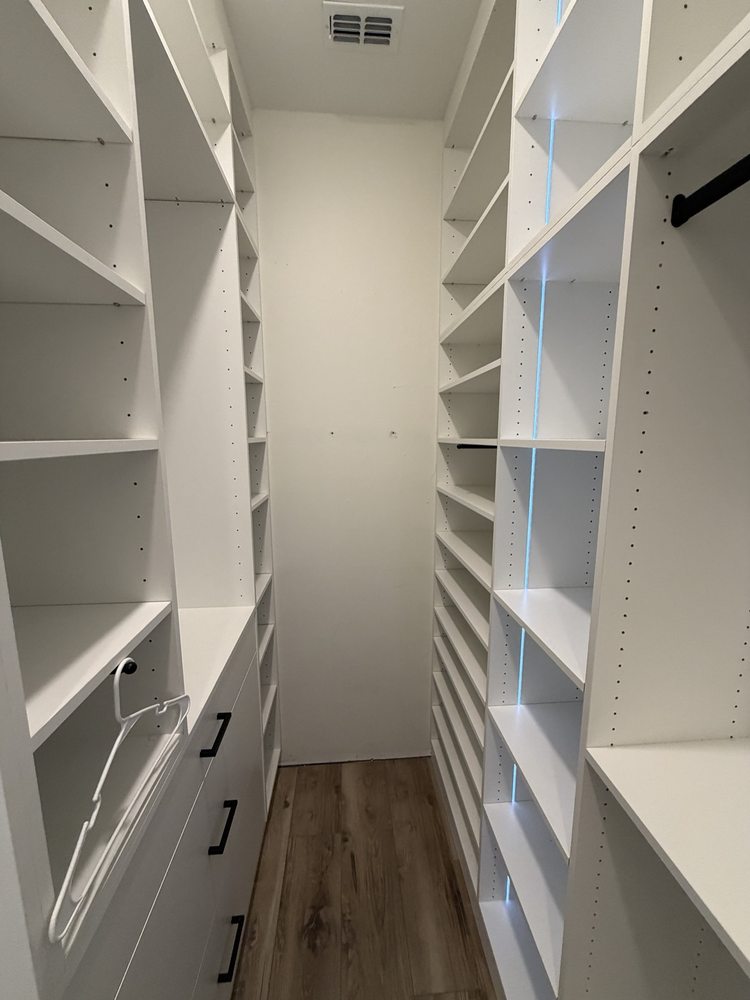 Closet shelving, drawers and hanging rails viewed from the opposite end