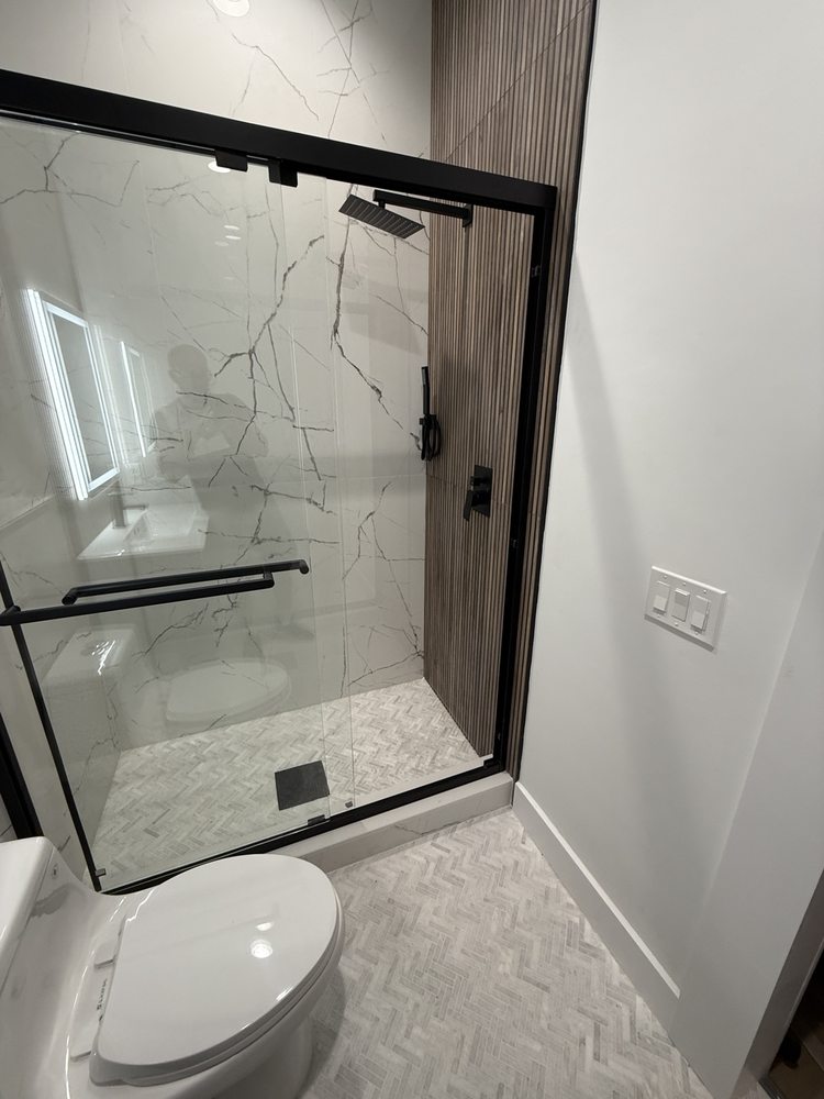 Closer view of a black-framed shower enclosure and tiled shower floor