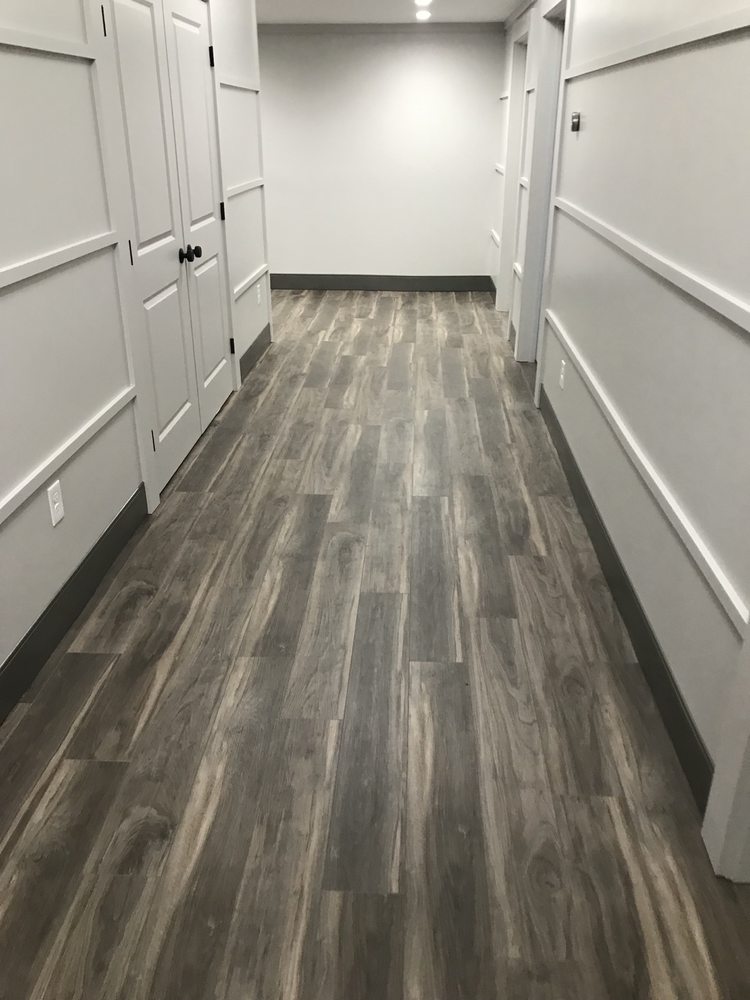 Wood-look hallway flooring with white decorative wall trim and doors