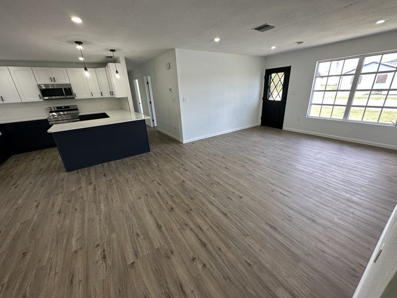 Continuous wood-look flooring across an open living area and kitchen