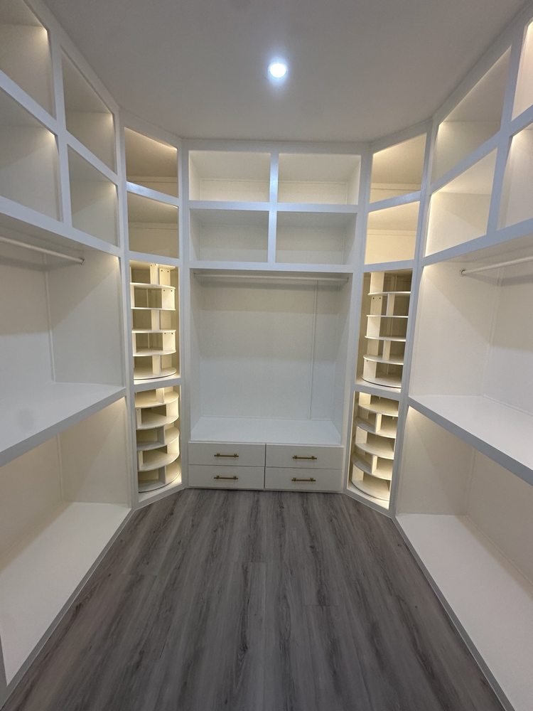 White walk-in closet storage with illuminated shelves, hanging rails and drawers