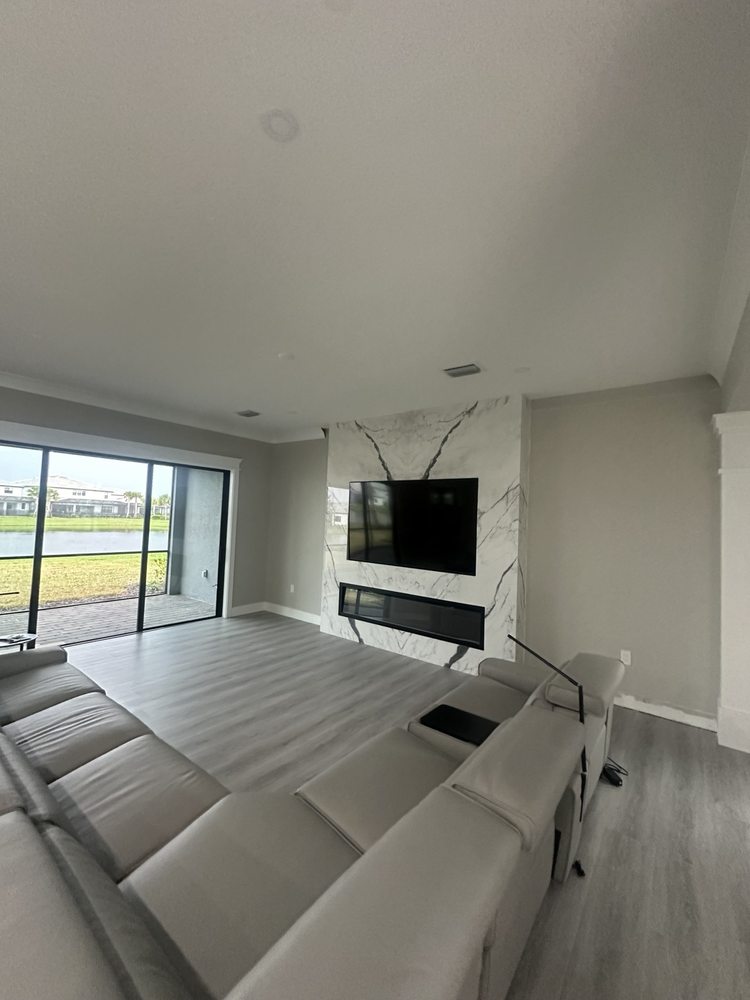 Living room with wood-look flooring and a marble-look television and fireplace feature wall