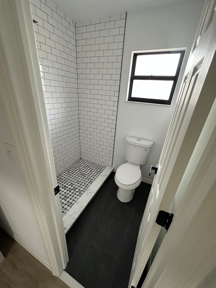 White subway-tiled shower with a mosaic floor