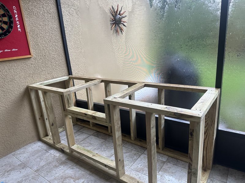 Outdoor kitchen framing on a screened patio during construction