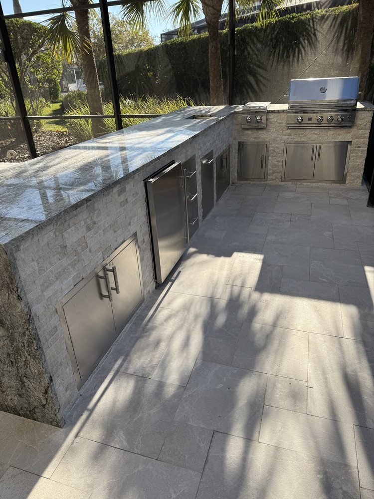 Outdoor kitchen with countertop, stainless steel access doors, refrigerator and grill