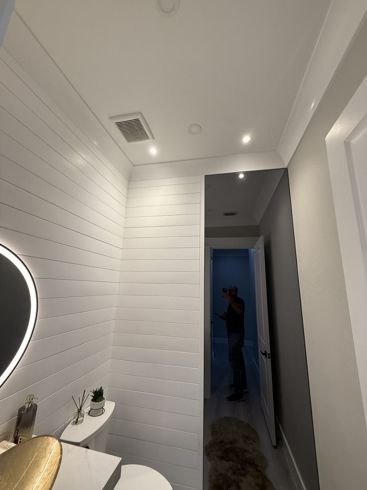 White horizontal wall paneling and recessed lighting in a powder room