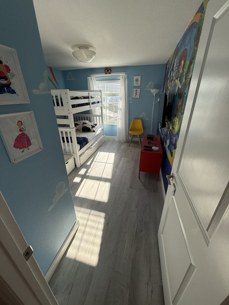 Wood-look flooring in a blue bedroom viewed through the doorway