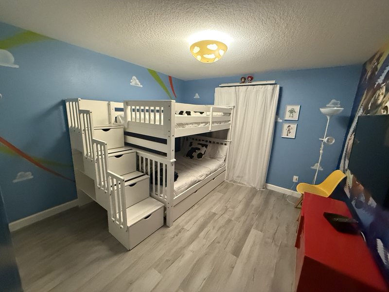 Wood-look flooring across a bedroom with blue walls and a white bunk bed