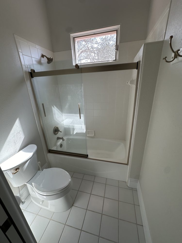 Bathroom with a glass shower enclosure and neutral floor tile