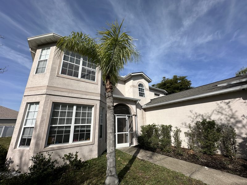 House front exterior with window bay and entrance arch
