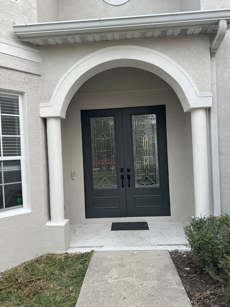 Dark double entry doors framed by a painted archway