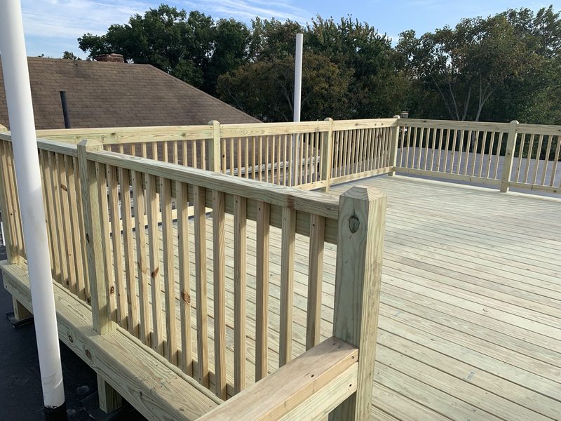 Outdoor deck surface and railing with exposed timber details