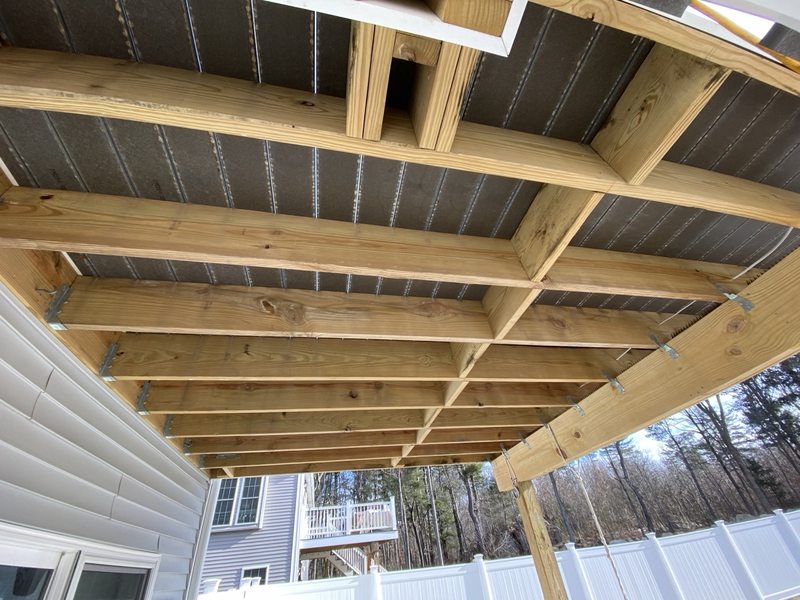 Exposed timber framing beneath an exterior deck