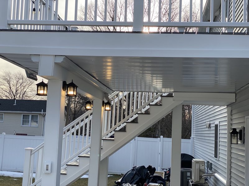 White PVC finishes beneath a raised exterior deck with stairs