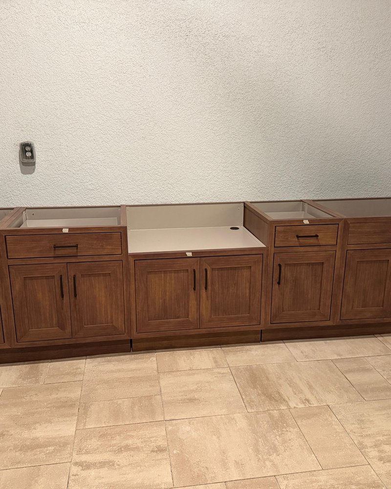 Installed outdoor kitchen base cabinets with a central appliance opening before countertop installation