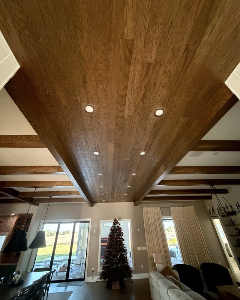 Wood-paneled ceiling with recessed lights and decorative wood beams