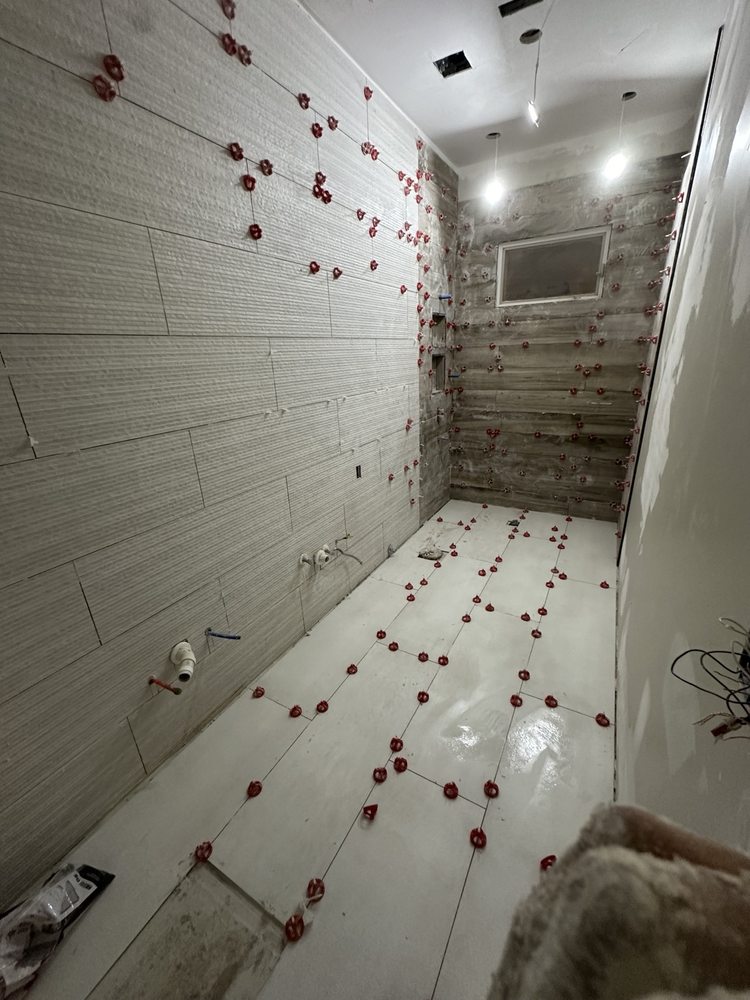 Wall and floor tile being installed with leveling clips
