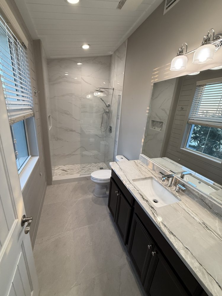 Bathroom vanity and a shower finished with light marble-look tile