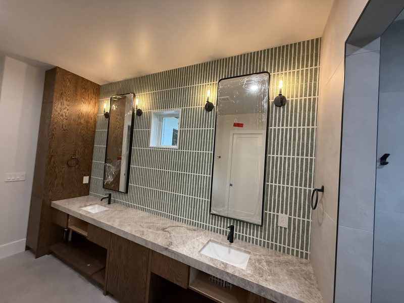 Double vanity with a tiled mirror wall and contrasting finishes