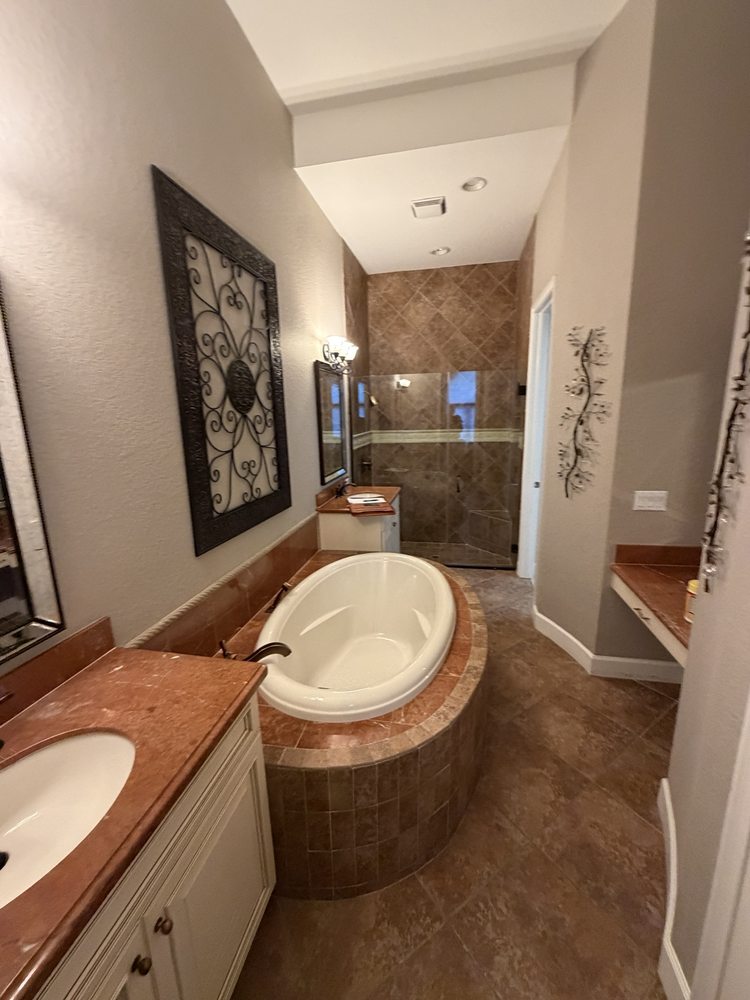 Bathroom with a bathtub, vanity and warm-toned finishes