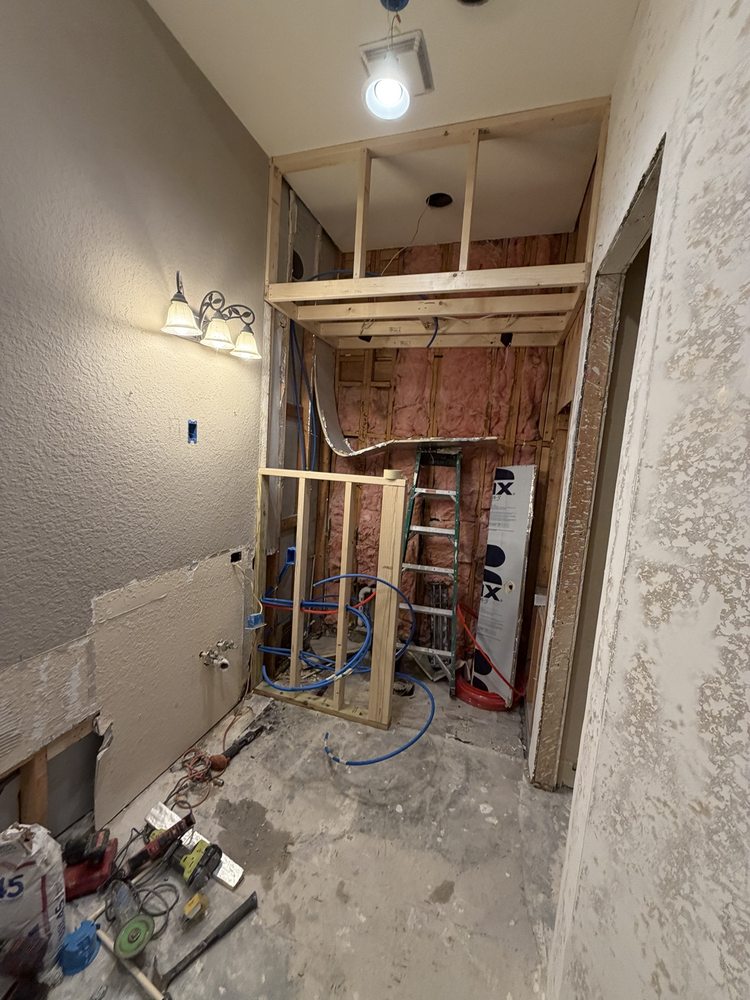 Bathroom during remodeling with exposed wall framing and plumbing