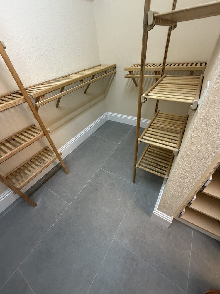 Closet with gray tile flooring and wood shelving
