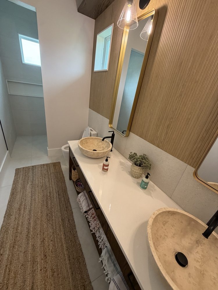 Double vessel-sink vanity with black faucets and gold-framed mirrors