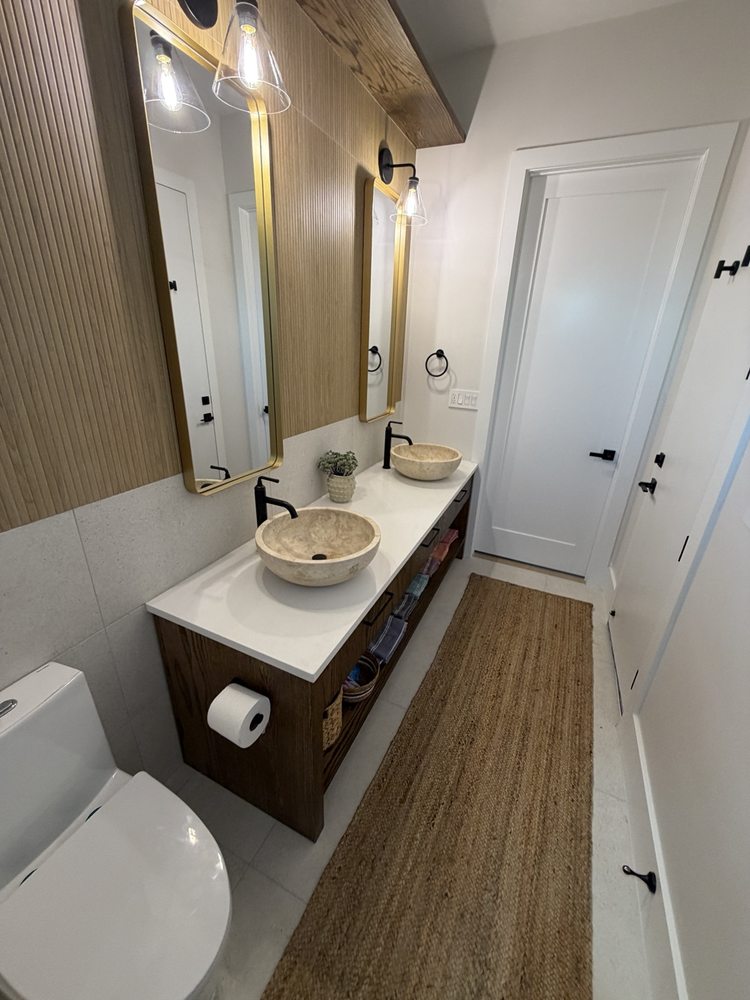Bathroom with a wood vanity, vessel sinks and light floor tile