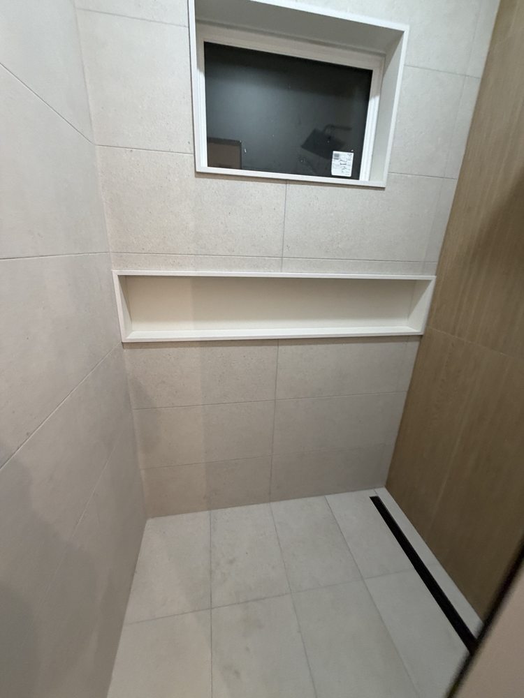 Wide shower niche beneath a window with light wall tile