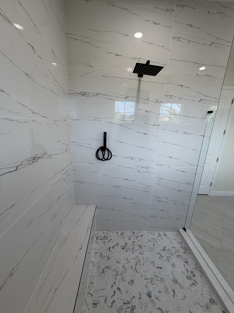 Shower with marble-look wall tile, built-in bench and black fixtures