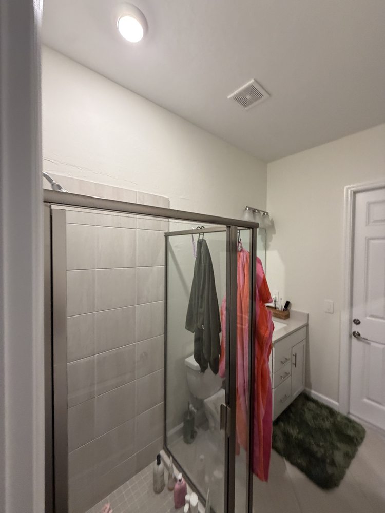 Bathroom with a glass enclosure and neutral tile finishes