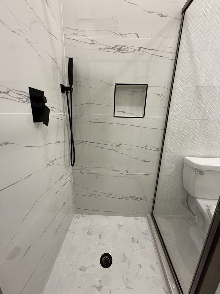 Recessed shower niche, marble-look tile and black shower fixtures