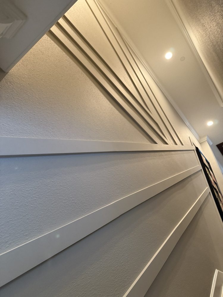 Decorative white wall trim and panel molding in a tall interior space