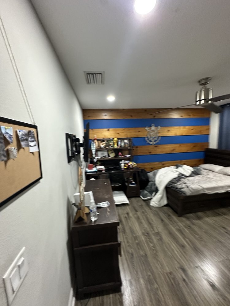 Bedroom featuring decorative wall trim and a wood accent wall