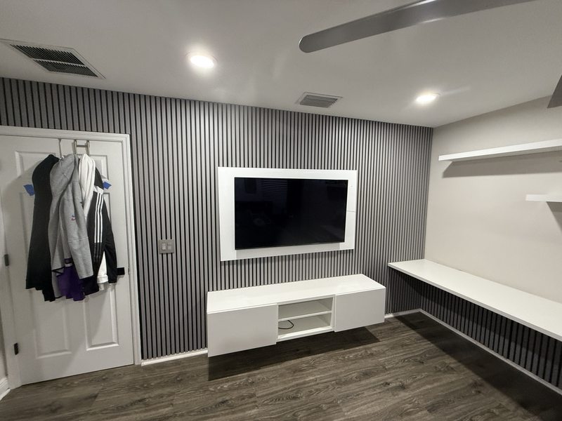 Slatted TV wall, white media cabinet and an adjacent desk area