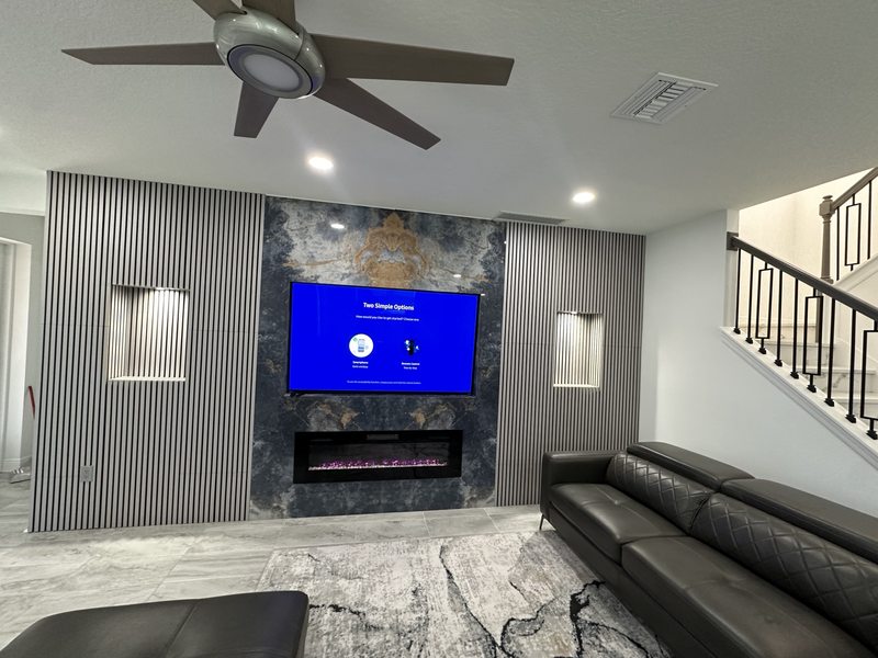 Media wall with slatted panels, illuminated niches, television and fireplace