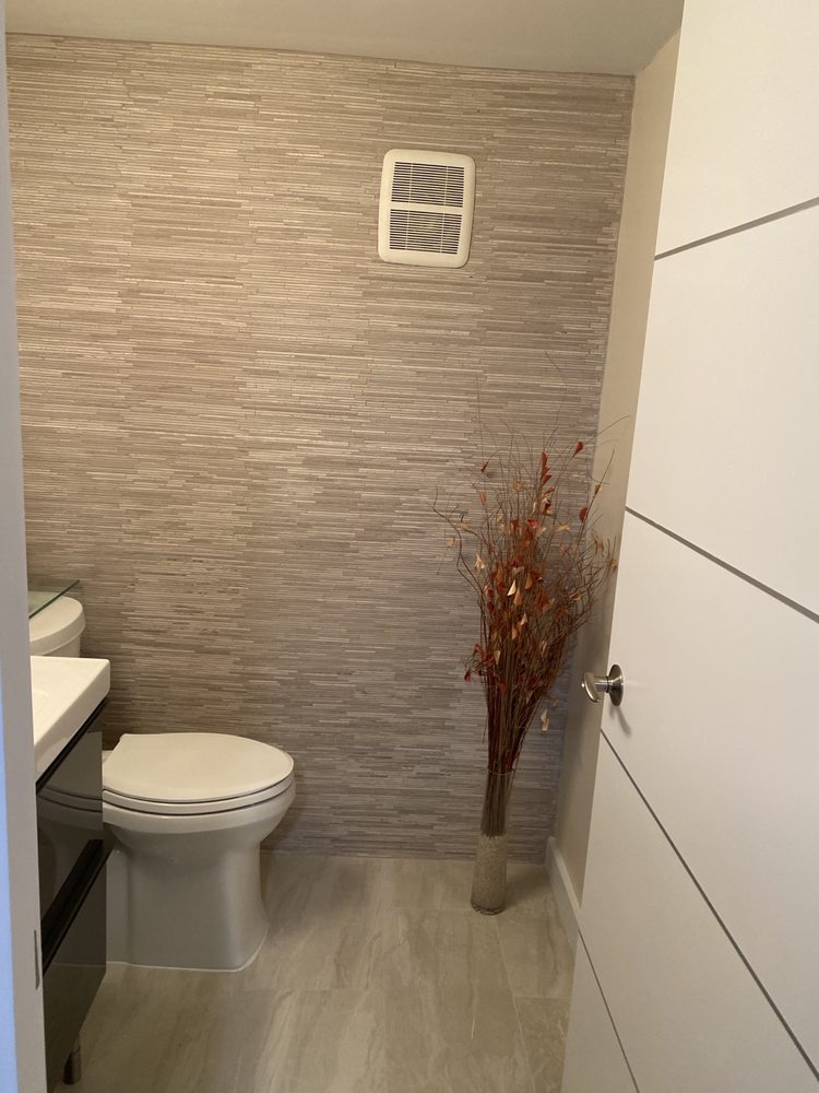 Bathroom with a textured decorative wall finish and light floor tile