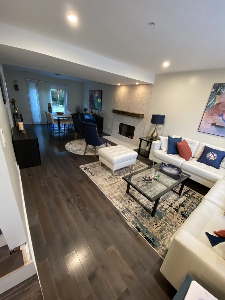 Living room with dark wood-look flooring and a textured fireplace surround