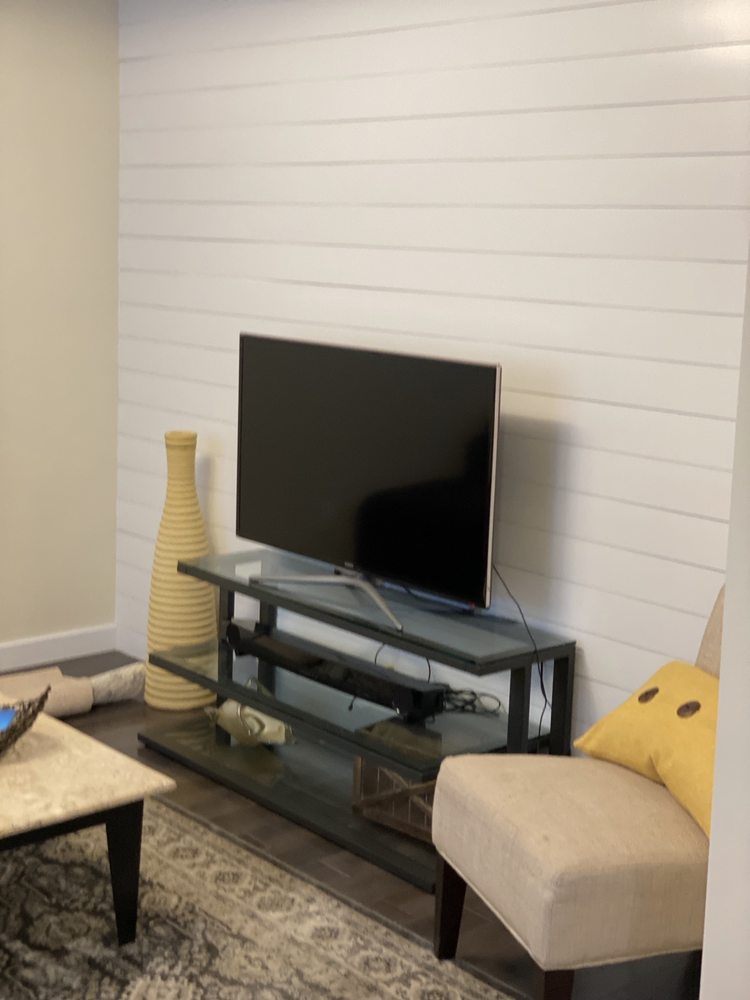 White horizontal wall paneling behind a television